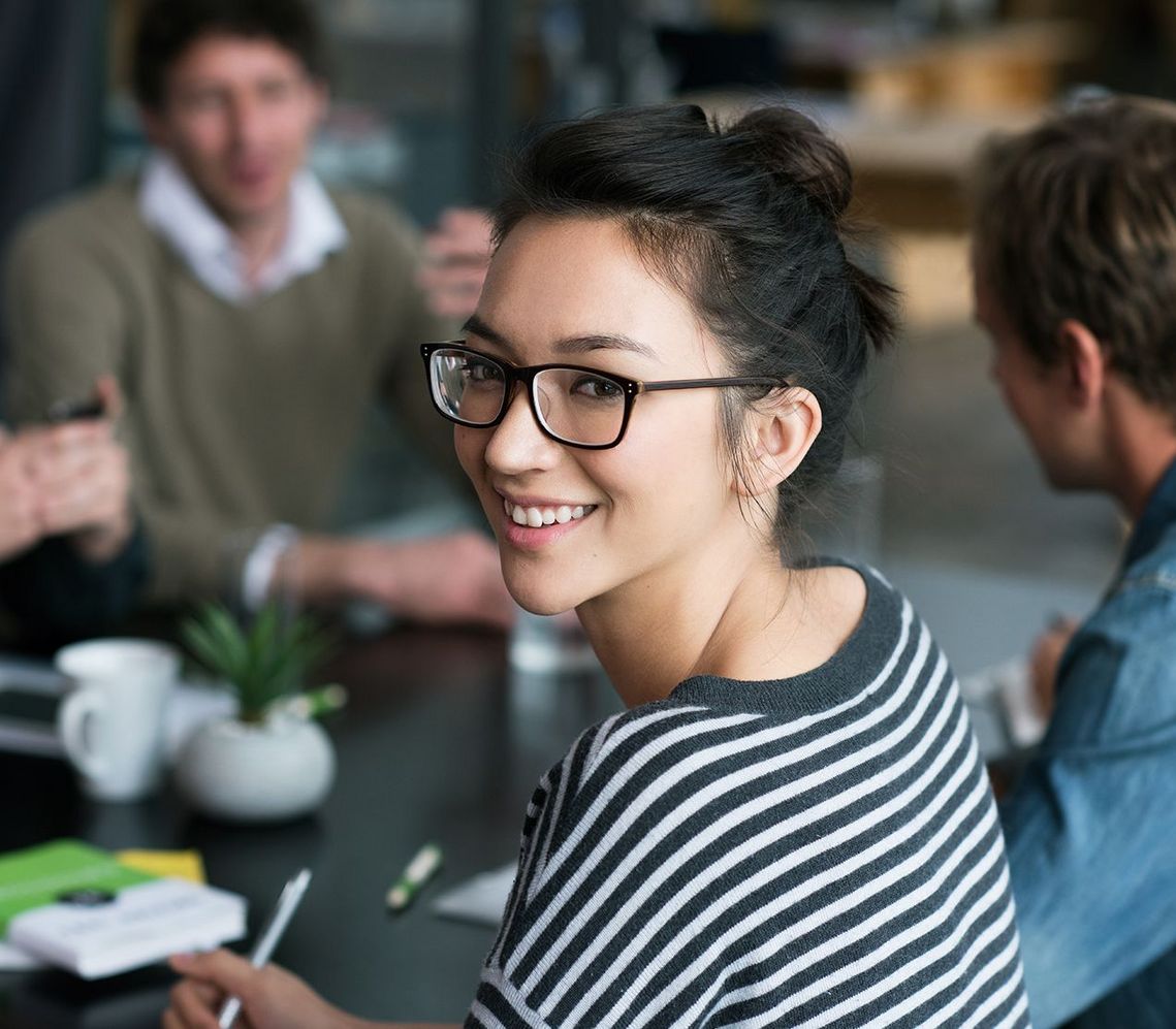Auf dem Bild sind vier glückliche und zufriedene Menschen zu sehen, welche die Zielgruppe der Weiterbildung repräsentieren.