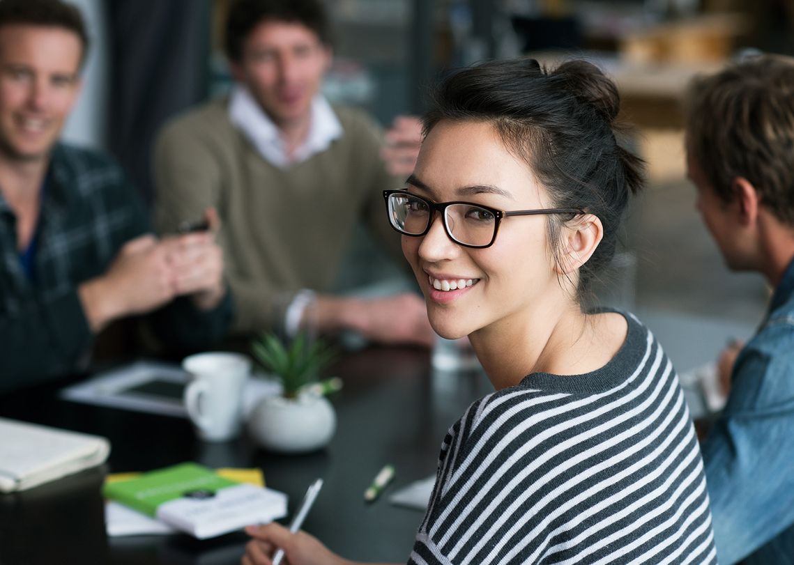 The picture shows four happy and satisfied people who represent the target group for further education.