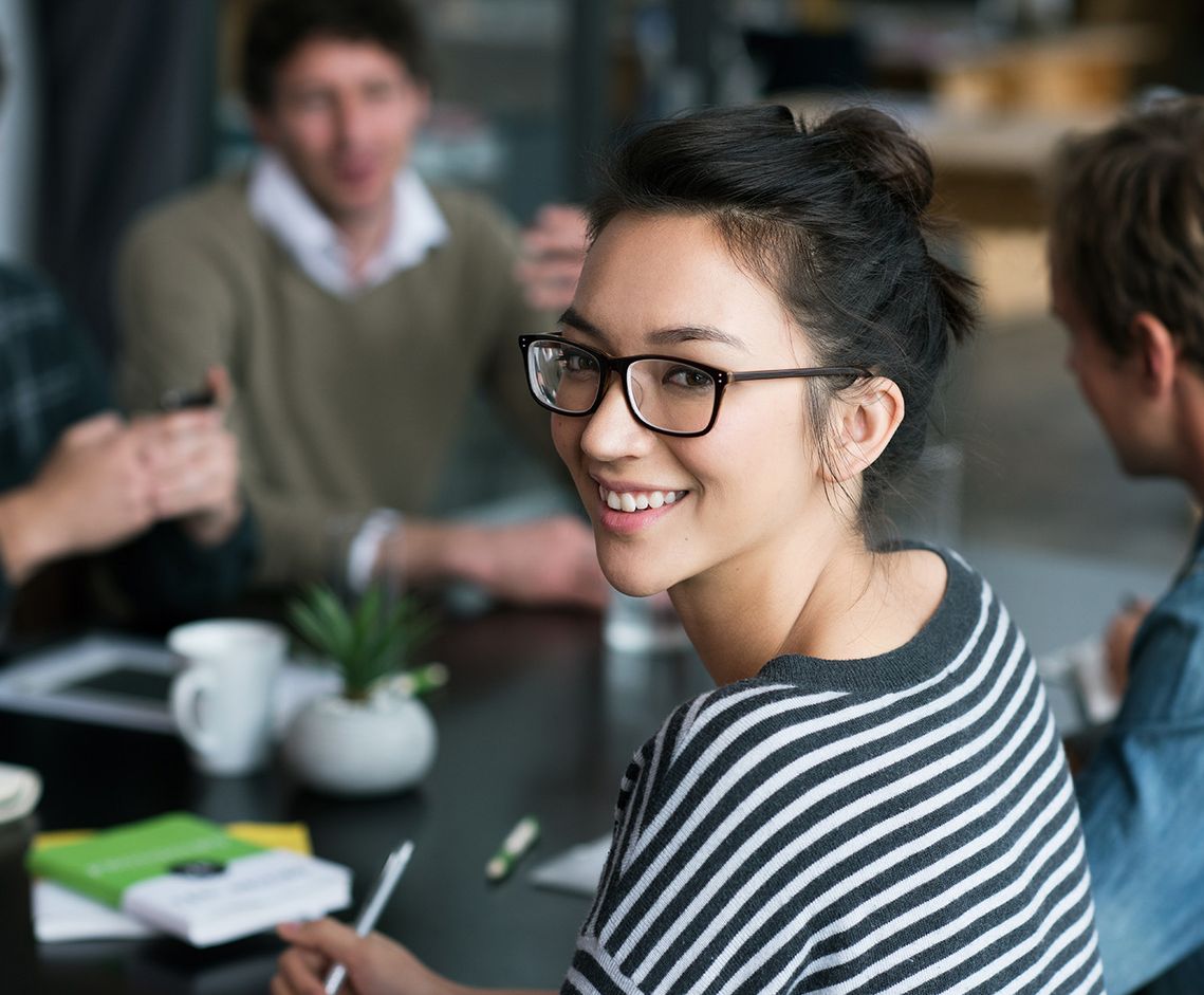 The picture shows four happy and satisfied people who represent the target group for further education.
