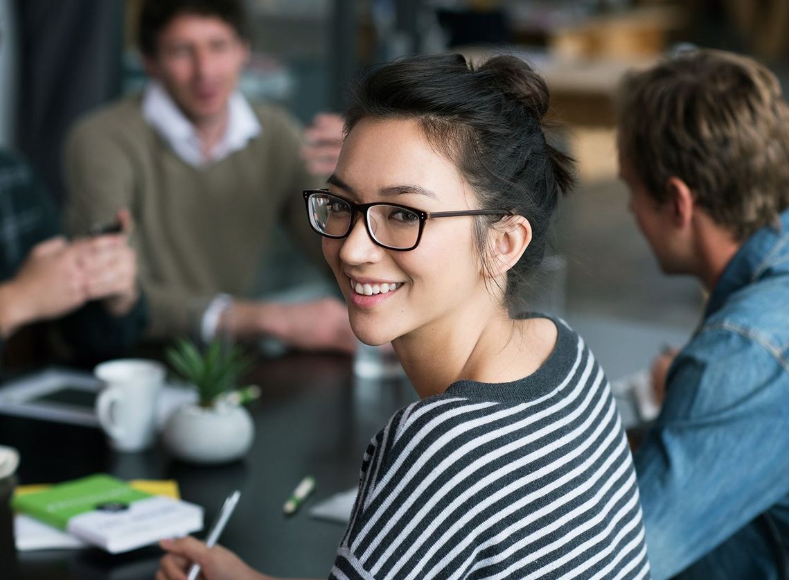 Auf dem Bild sind vier glückliche und zufriedene Menschen zu sehen, welche die Zielgruppe der Weiterbildung repräsentieren.