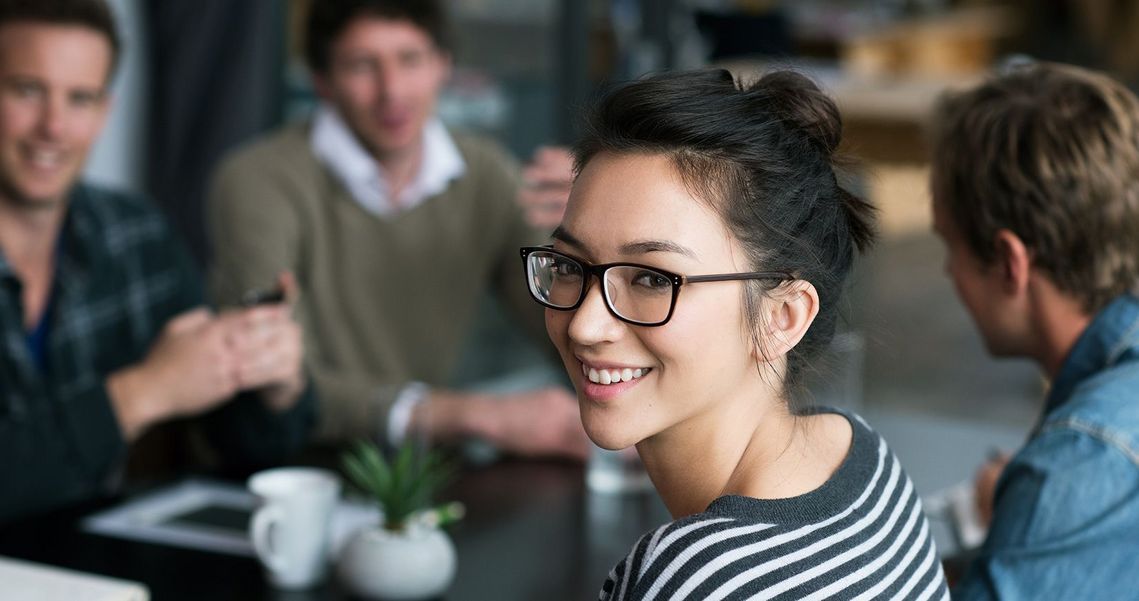 Auf dem Bild sind vier glückliche und zufriedene Menschen zu sehen, welche die Zielgruppe der Weiterbildung repräsentieren.