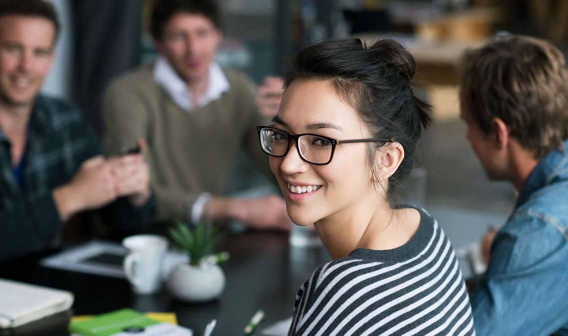 Auf dem Bild sind vier glückliche und zufriedene Menschen zu sehen, welche die Zielgruppe der Weiterbildung repräsentieren.