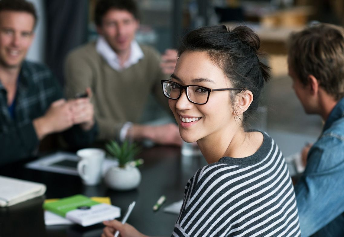 Auf dem Bild sind vier glückliche und zufriedene Menschen zu sehen, welche die Zielgruppe der Weiterbildung repräsentieren.