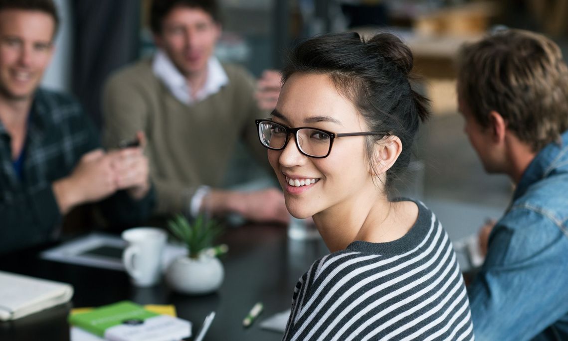 Auf dem Bild sind vier glückliche und zufriedene Menschen zu sehen, welche die Zielgruppe der Weiterbildung repräsentieren.