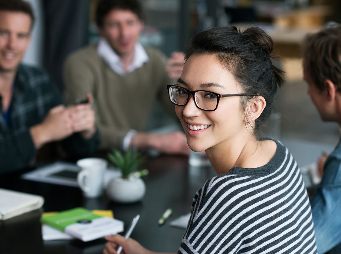 The picture shows four happy and satisfied people who represent the target group of the further education programme.