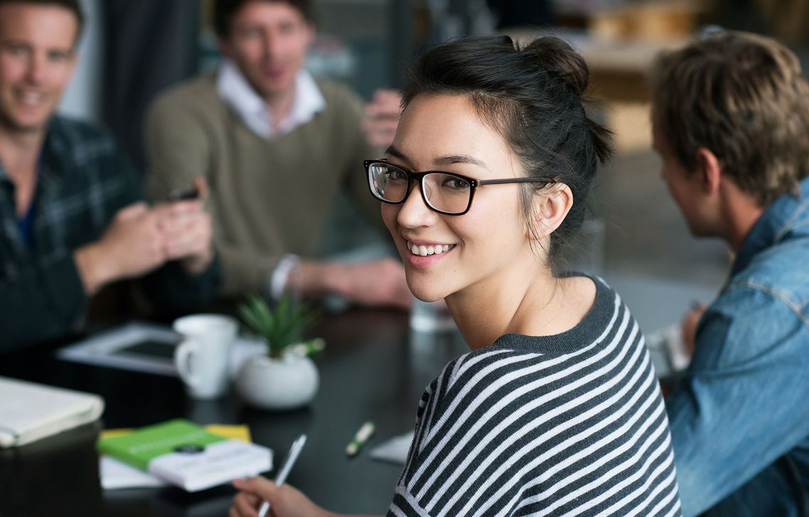 Auf dem Bild sind vier glückliche und zufriedene Menschen zu sehen, welche die Zielgruppe der Weiterbildung repräsentieren.