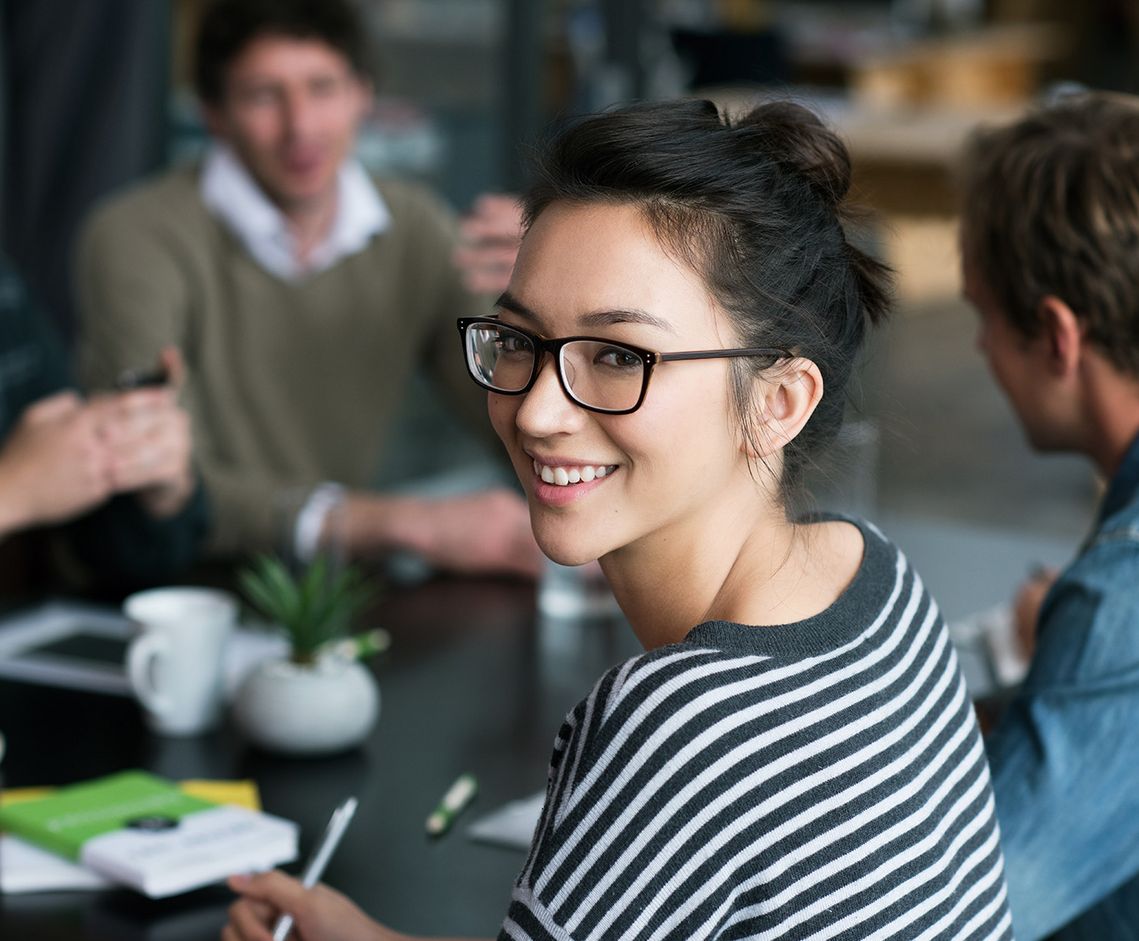 The picture shows four happy and satisfied people who represent the target group of the further education programme.