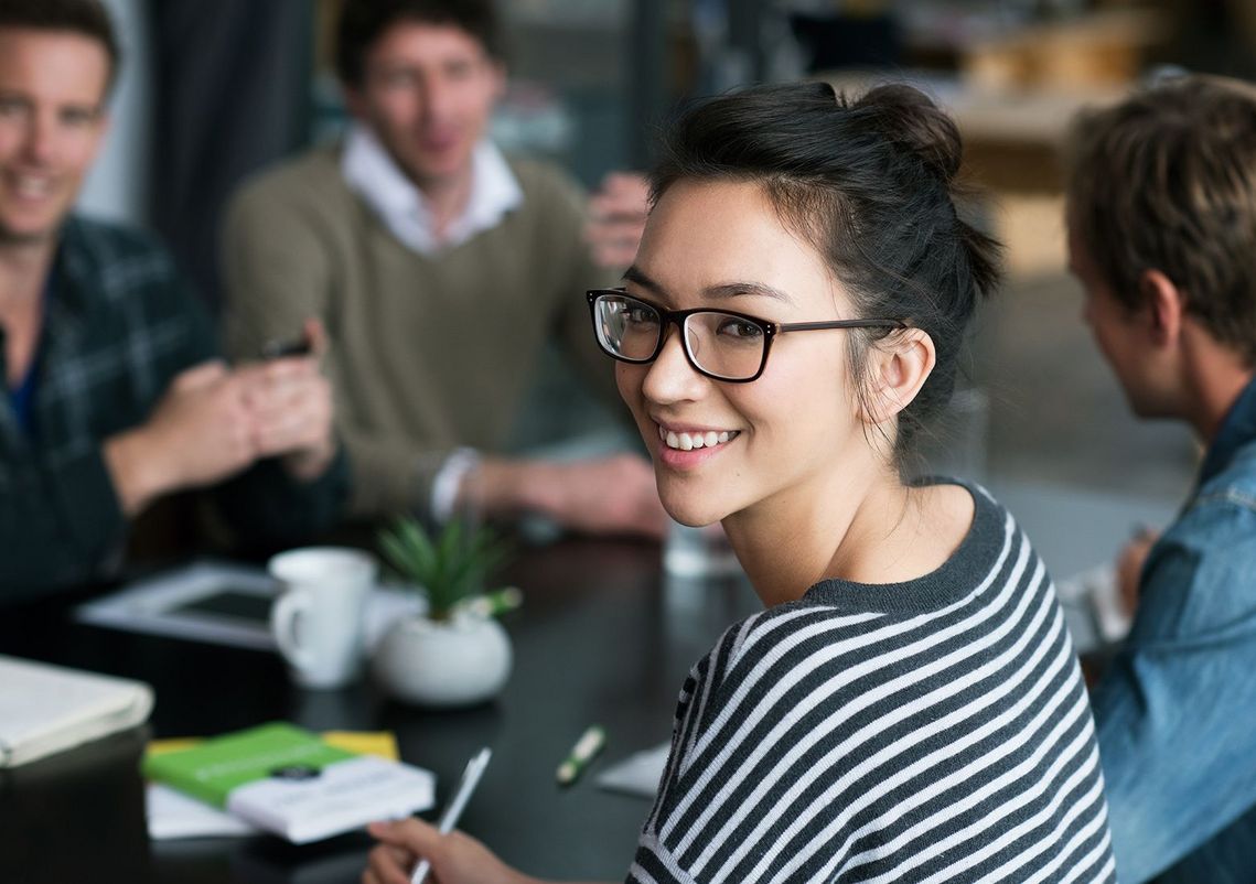 Auf dem Bild sind vier glückliche und zufriedene Menschen zu sehen, welche die Zielgruppe der Weiterbildung repräsentieren.