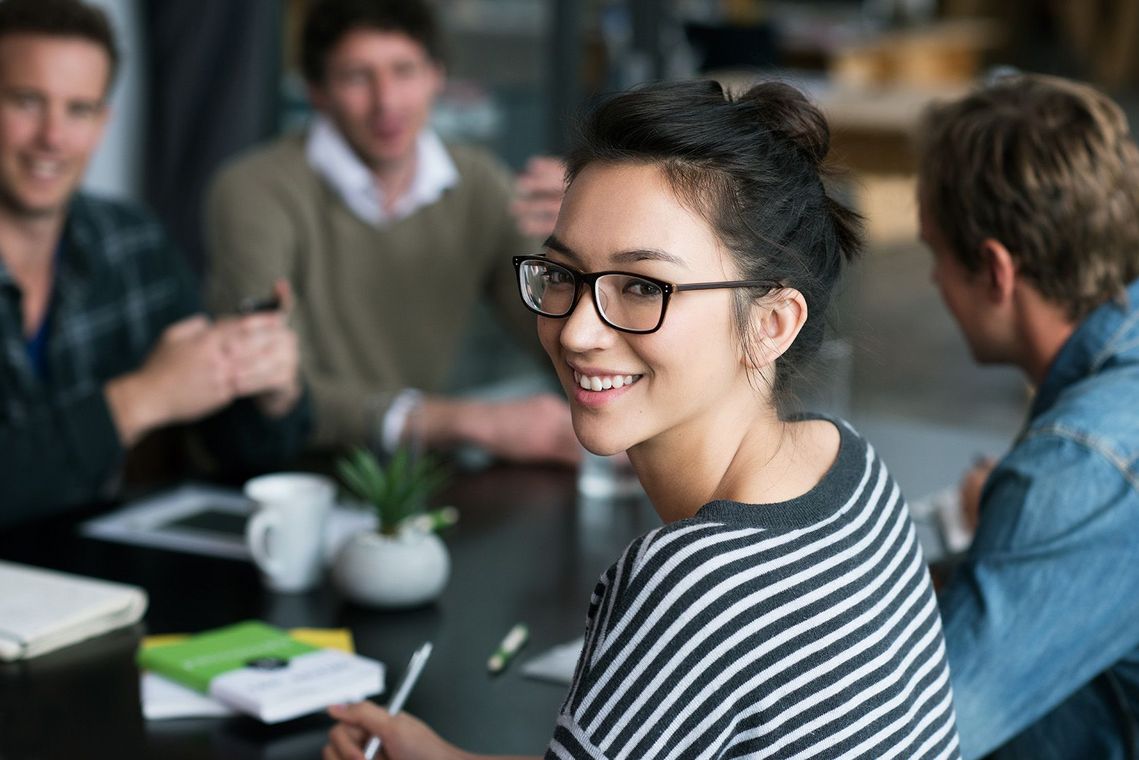 Auf dem Bild sind vier glückliche und zufriedene Menschen zu sehen, welche die Zielgruppe der Weiterbildung repräsentieren.