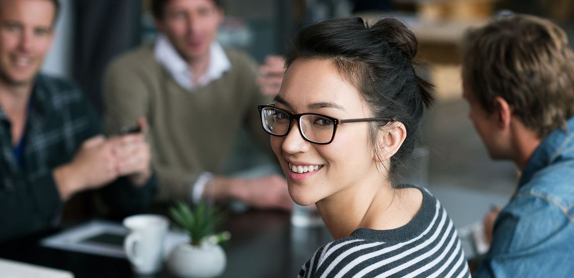 Auf dem Bild sind vier glückliche und zufriedene Menschen zu sehen, welche die Zielgruppe der Weiterbildung repräsentieren.