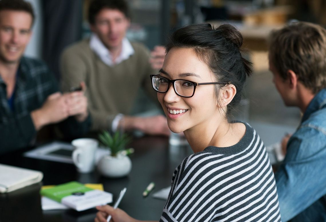 Auf dem Bild sind vier glückliche und zufriedene Menschen zu sehen, welche die Zielgruppe der Weiterbildung repräsentieren.