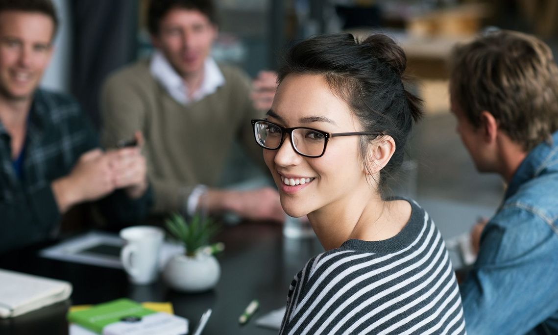 Auf dem Bild sind vier glückliche und zufriedene Menschen zu sehen, welche die Zielgruppe der Weiterbildung repräsentieren.