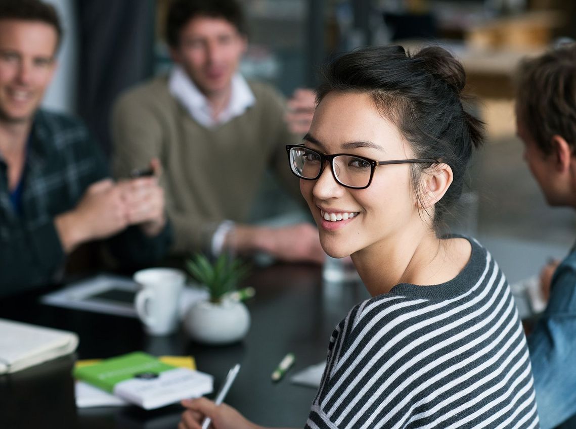 Auf dem Bild sind vier glückliche und zufriedene Menschen zu sehen, welche die Zielgruppe der Weiterbildung repräsentieren.