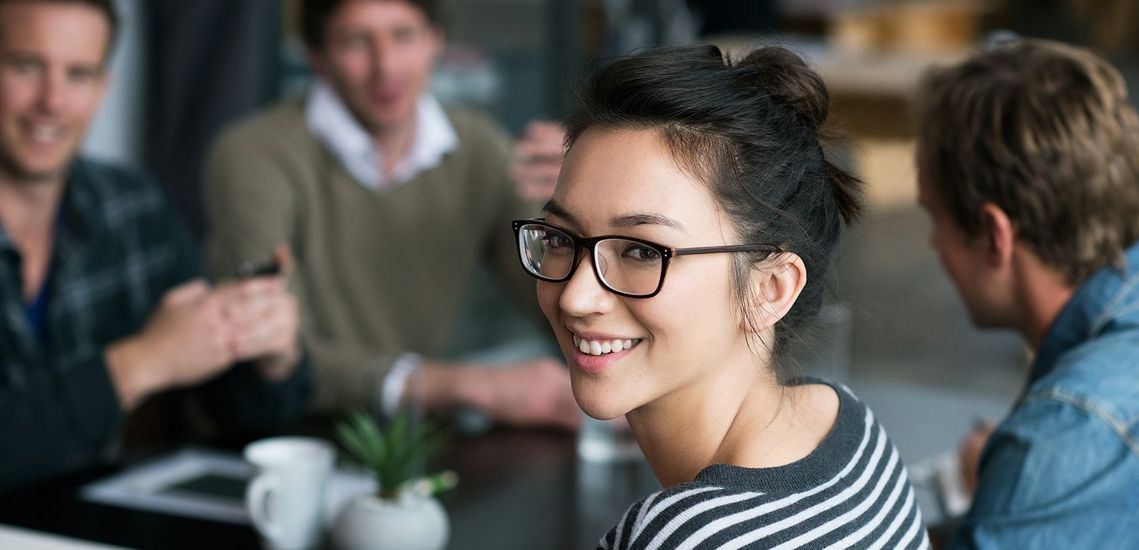 Auf dem Bild sind vier glückliche und zufriedene Menschen zu sehen, welche die Zielgruppe der Weiterbildung repräsentieren.
