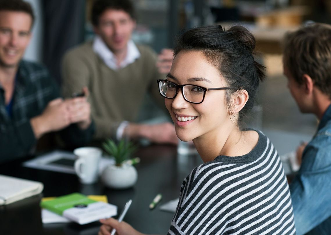 Auf dem Bild sind vier glückliche und zufriedene Menschen zu sehen, welche die Zielgruppe der Weiterbildung repräsentieren.