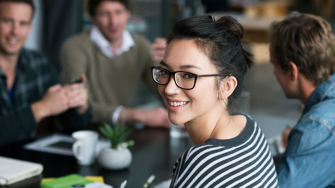 Auf dem Bild sind vier glückliche und zufriedene Menschen zu sehen, welche die Zielgruppe der Weiterbildung repräsentieren.