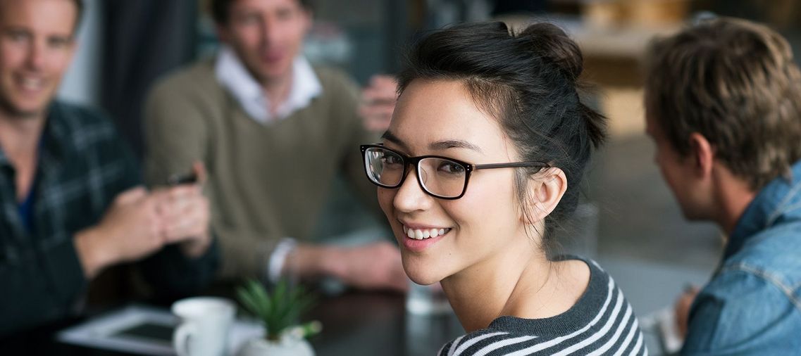 Auf dem Bild sind vier glückliche und zufriedene Menschen zu sehen, welche die Zielgruppe der Weiterbildung repräsentieren.