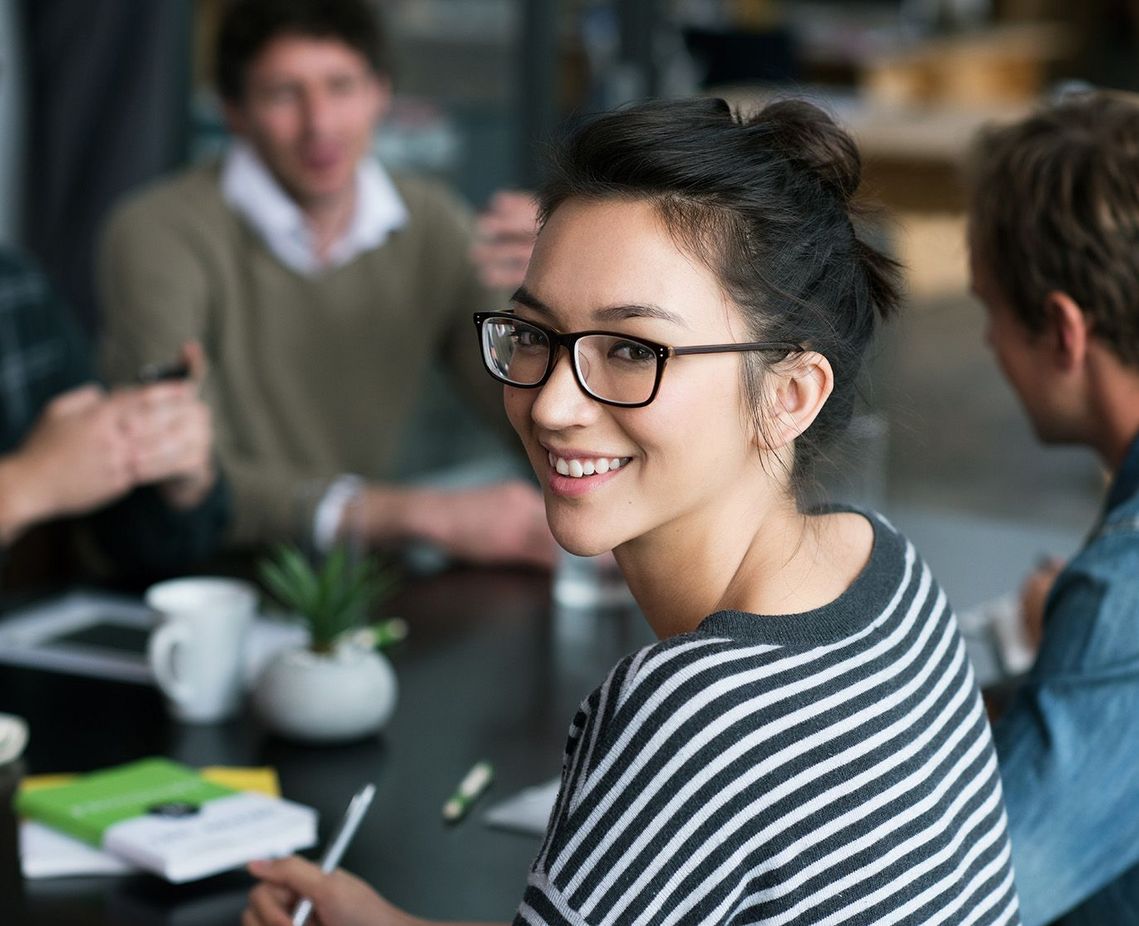 Auf dem Bild sind vier glückliche und zufriedene Menschen zu sehen, welche die Zielgruppe der Weiterbildung repräsentieren.
