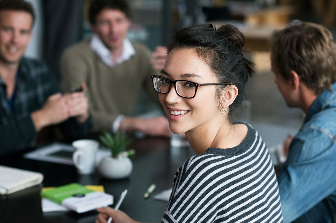 Auf dem Bild sind vier glückliche und zufriedene Menschen zu sehen, welche die Zielgruppe der Weiterbildung repräsentieren.