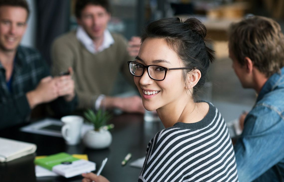 Auf dem Bild sind vier glückliche und zufriedene Menschen zu sehen, welche die Zielgruppe der Weiterbildung repräsentieren.
