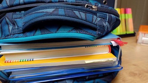 A pile of textbooks in an open school rucksack. 