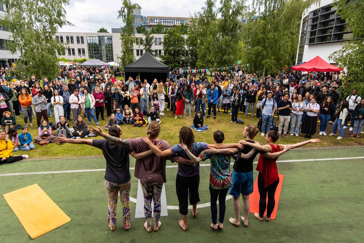 Acro Yoga Performer*innen verbeugen sich vor einem großen Publikum.