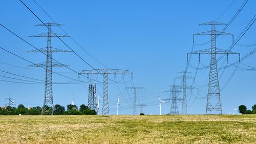 Landscape with power lines and wind turbines on the horizon.