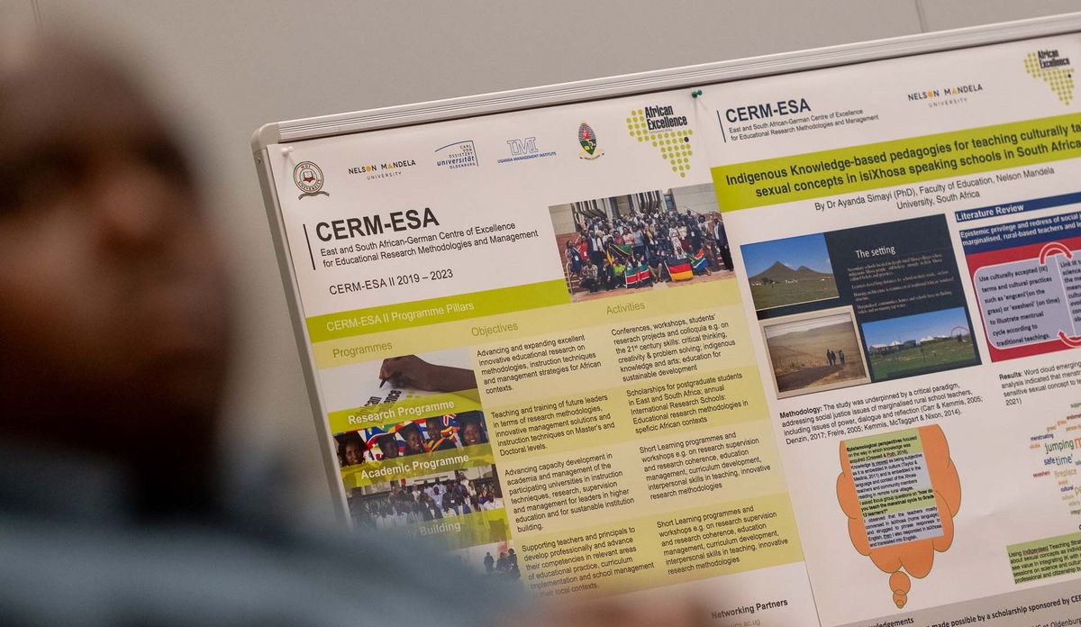 Das Bild zeigt eine Nahaufnahme eines Posters mit einem nicht vollständig lesbaren Titel. Das Poster ist mit Text, Diagrammen und Logos, u. a. der Nelson Mandela University, der Uni Oldenburg und des CERM-ESA (East and South African-German Centre of Excellence for Educational Research Methodologies and Management) gefüllt. Es handelt sich um eine wissenschaftliche Arbeit, die sich mit pädagogischen Ansätzen und Forschungsergebnissen befasst.