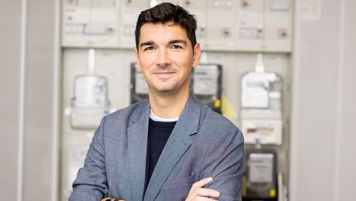 Portraitfoto des Wirtschaftsinformatikers Prof. Dr. Philipp Staudt. Er steht vor einem Stromkasten. 