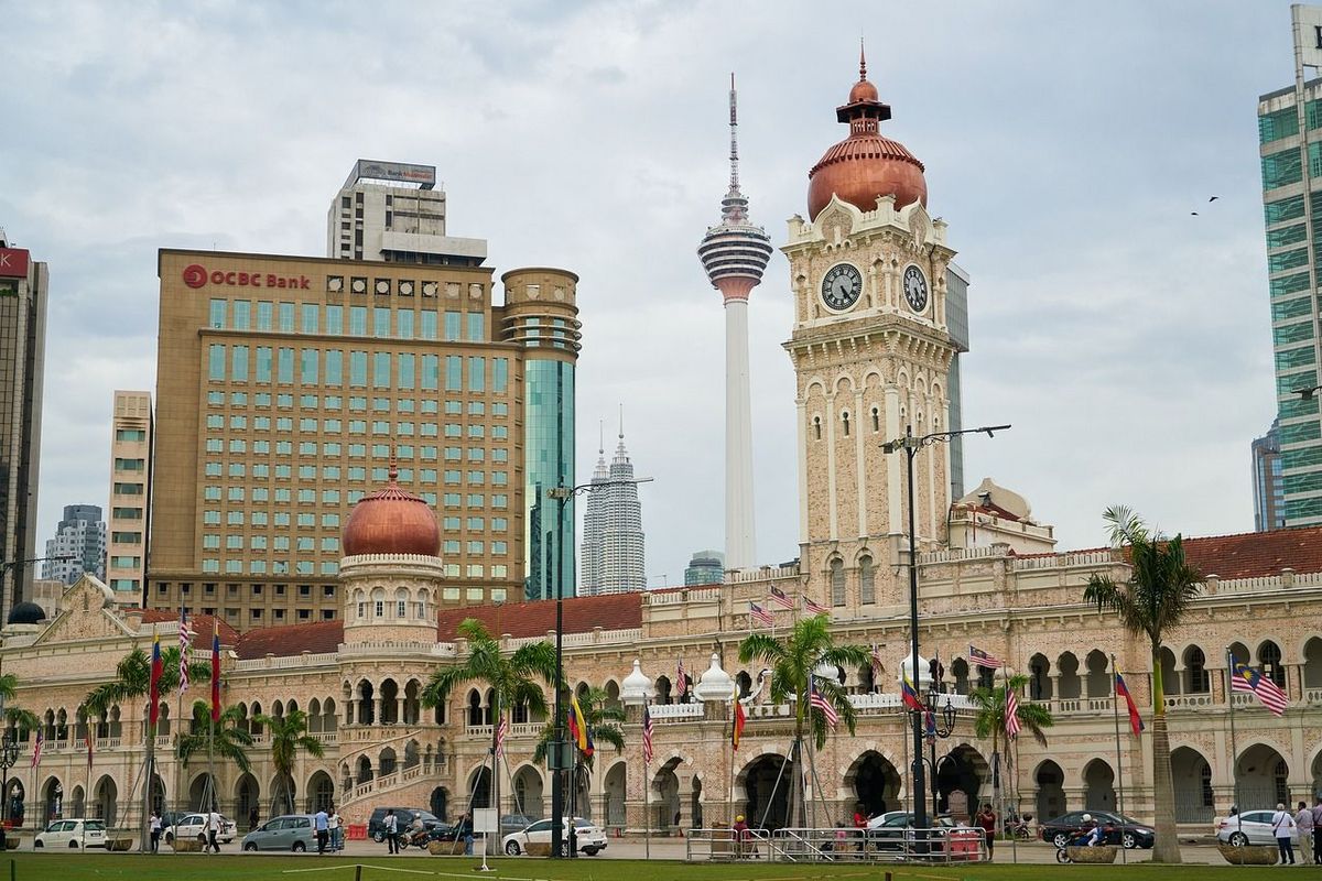 Das Sultan Abdul Samad Building und der Kuala Lumpur Tower in Kuala Lumpur, Malaysia. Ein historisches Gebäude mit Kuppeln.