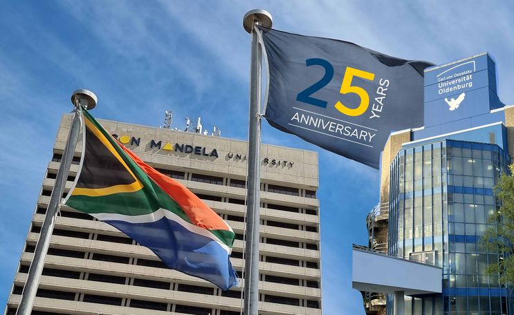 Universitätsgebäude der NMU und der UOL mit Flagge, auf der das Kooperationslogo zu sehen ist