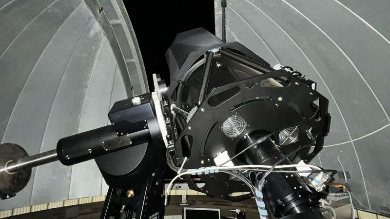 Das große Teleskop ist von unten zu sehen, es richtet sich durch das Beobachtungsfenster auf den dunklen Himmel. 