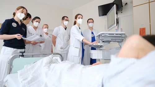 The apprentices and students at the bedside during morning rounds.