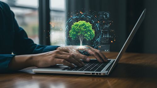 Hände am Laptop hinter einem Baum und digitale Icons