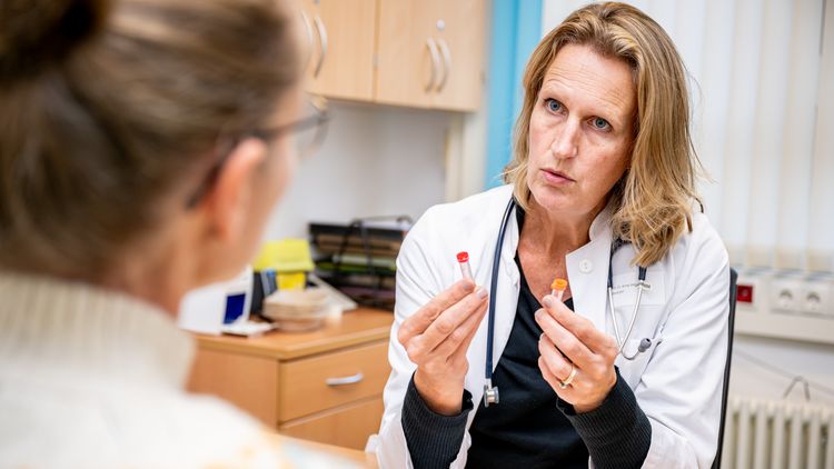 Anne Hilgendorff during an informed consent discussion. She is holding two small, unused blood tubes in her hand.