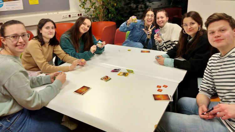 Internationale Studierende sitzen an einem Tisch im Rahmen des Spieleabends während der Welcome Week