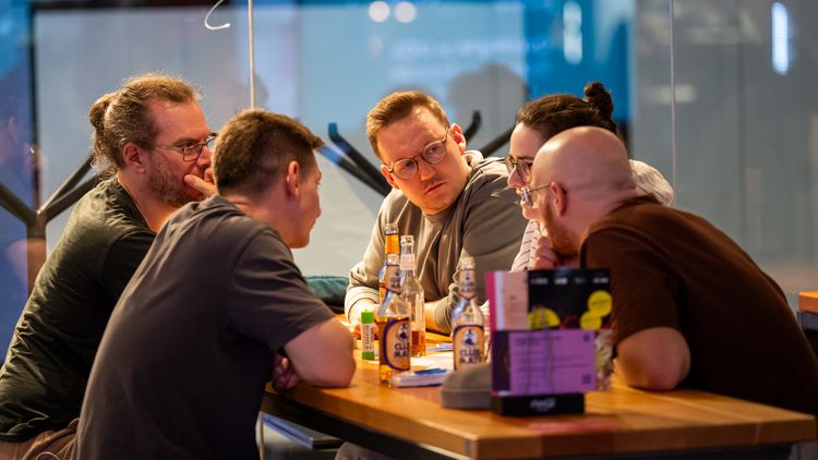 A quiz team sitting around a table, thinking about one of the questions.