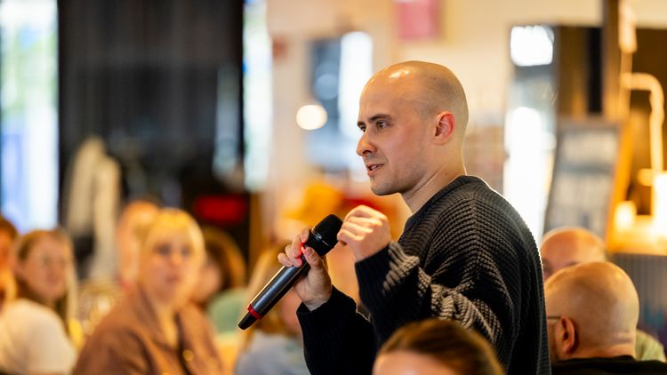 A guest ist speaking into a microphone.