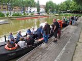 The alumni sit in a peat barge on the water.