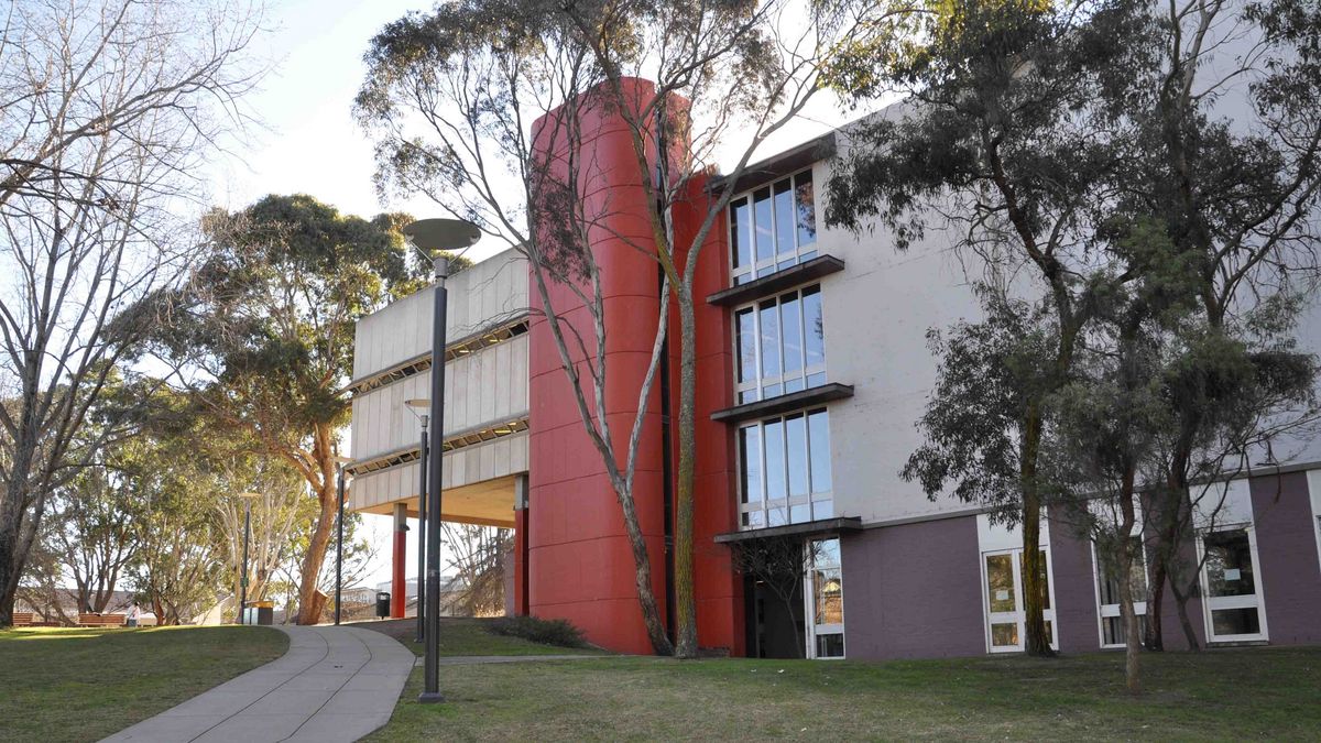 Ein markantes Gebäude auf dem Campus der University of New England. Moderne Architektur mit Beton, Glas und einem roten Zylinder.