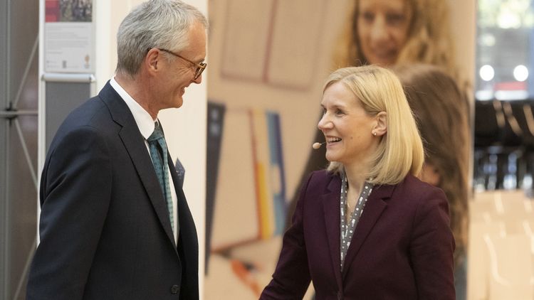 Jutta Günther is talking to a grey-haired man in a dark suit. 