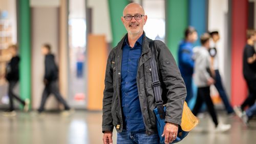 Oldenburg educational scientist Prof Dr Till-Sebastian Idel in an Oldenburg school foyer with pupils in the background.