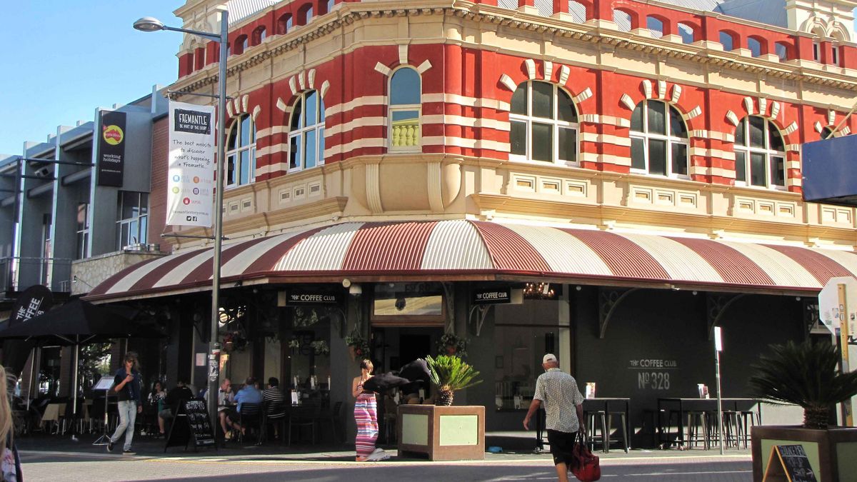 Das historische Fremantle Post Office in Westaustralien mit rot-weiß gestreifter Fassade und einem Café.