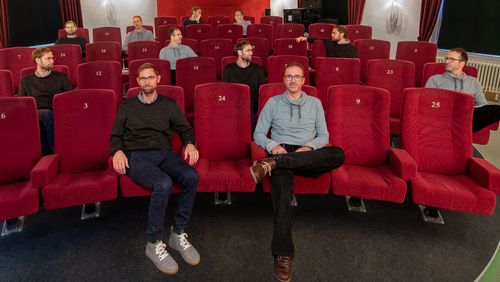 Bildmontage: Kai Siedenburg und Martin Bleichner sitzen in verschiedenen Positionen auf verschiedenen Plätzen eines Kinosaals.