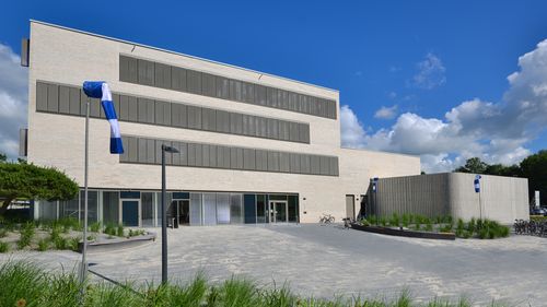 Exterior view of the WindLab: three-storey building with characteristic shutters and the wind tunnel as an extension