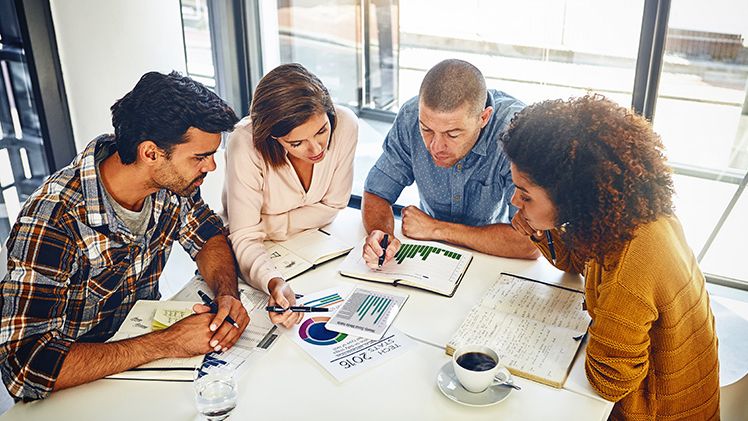 Team, meeting and review with statistics and charts on company goals, kpi or market research with data analysis. Above, table or paper report on growth,
