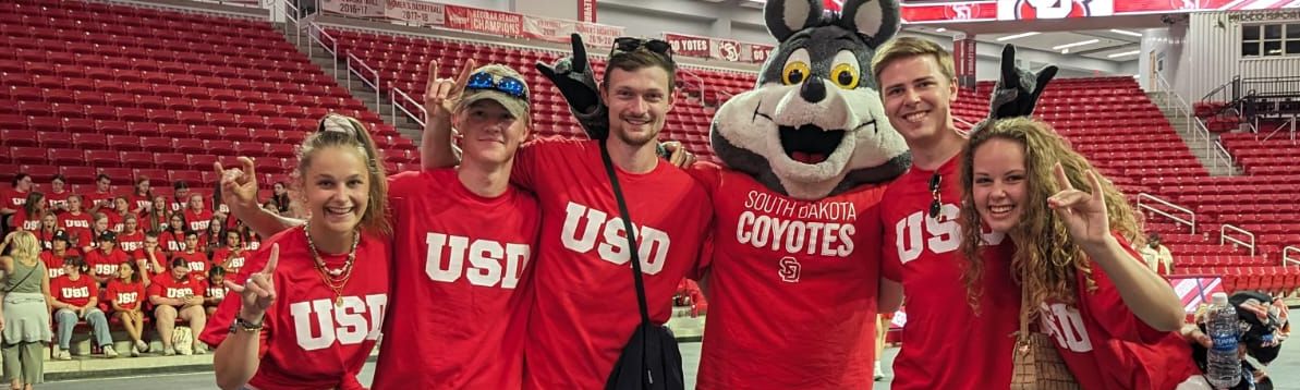 Group of people posing with the South Dakota Coyotes mascot.
