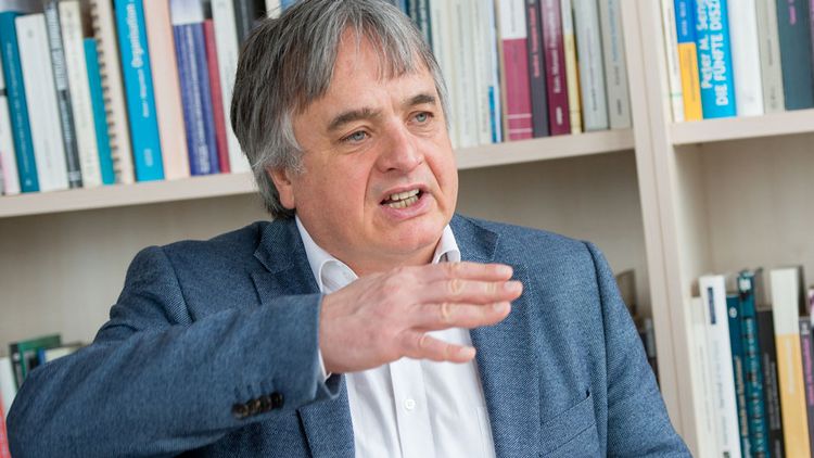 Porträtfoto des Sozialwissenschaftlers Martin Heidenreich vor einer Bücherwand.