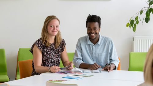 Tash Motsi sitting with another student at a table in the "Interkulturelle Treff".