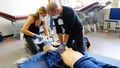 Two students are practicing resuscitation on a manikin.